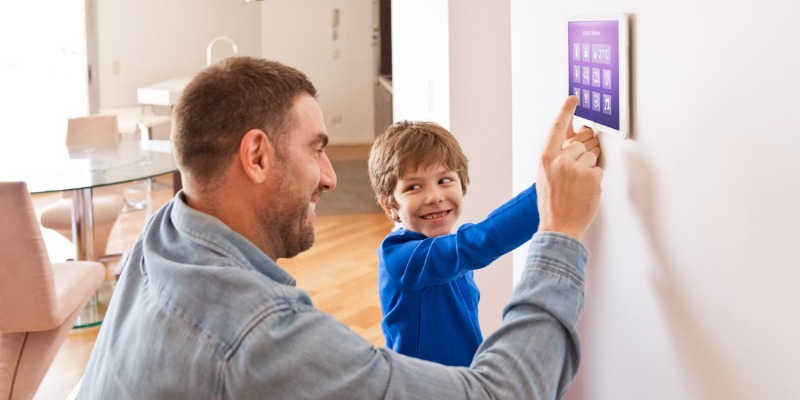 father and son adjusting smart thermostat